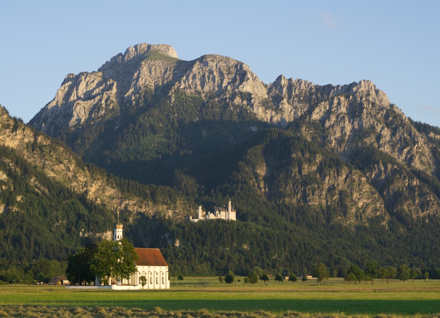 Panorama von Schwangau im Allgäu mit Bergen und Schloss Neuschwanstein und Colomanskirche